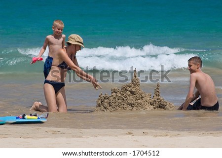 Happy family building sand castles on the beach, Hawaii