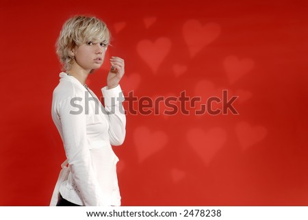 Blonde Girl in white shirt,in  a front of red background with harts, expresses her emotions