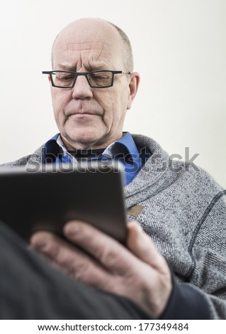 Older man reading on tablet pc