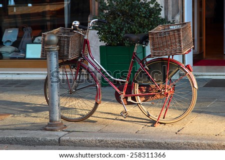 Old vintage bicycle with big basket on the street of old town Parma in Italy