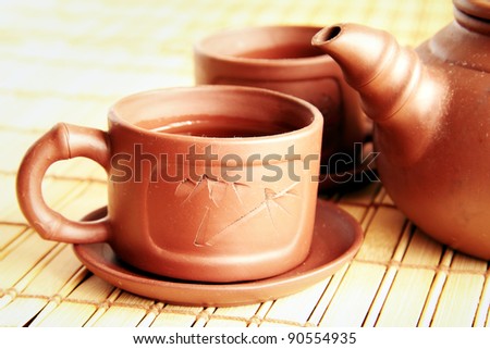 Chinese clay teapot, two cups and green tea