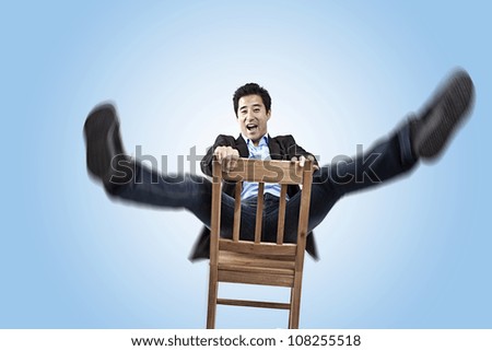 attractive Business man falls off chair an looks at you