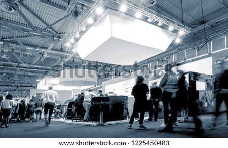 business people walking between trade show booths at a public event exhibition hall