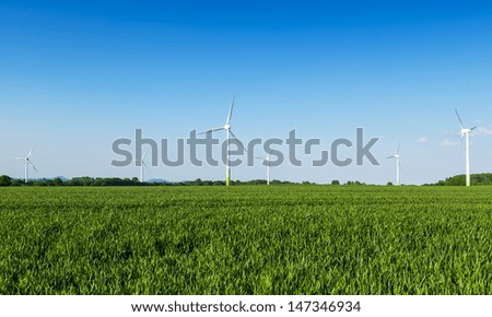 wind wheels in a field wind-turbine wind farm against blue sky agriculture