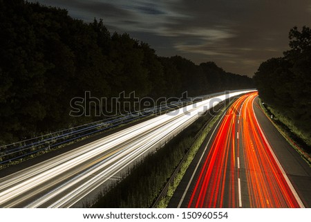 long time exposure on a highway with car light trails and cloudy sky