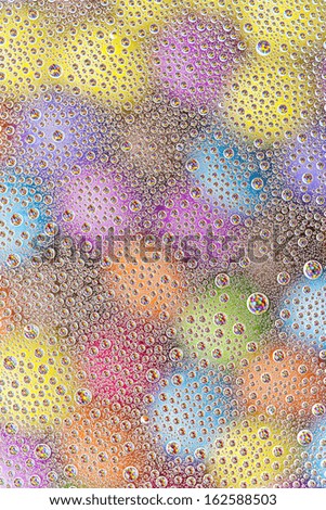 water drops on colorful orange blue yellow sweet candy Sugar love pearls refraktion background