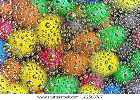 water drops on colorful orange blue yellow sweet candy chocolate lentils background