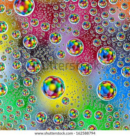 water drops on colorful orange blue yellow sweet candy chocolate lentils background