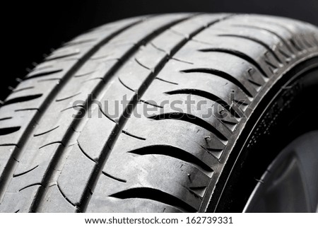 Car summer tires close-up wheel worn profile structure on black background