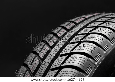 Car tires close-up Winter wheel profile structure on black background