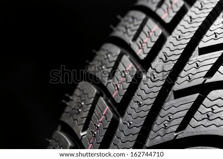 Car tires close-up Winter wheel profile structure on black background
