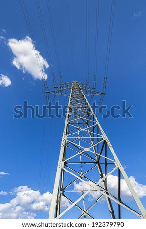 electricity pylon on blue sky with clouds from a different perspective