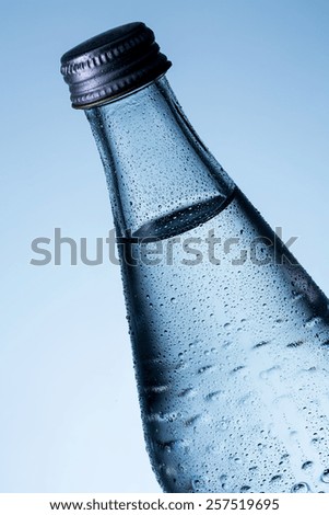 Glass bottle of water with dew drops