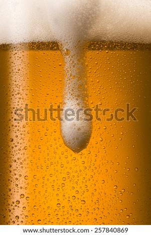 overflowing cold german beer with dew drops