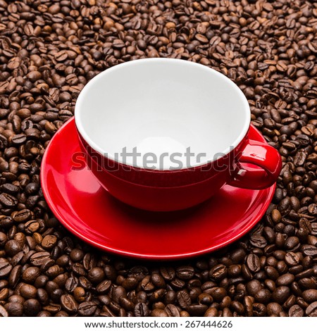 empty red coffee cup on roasted beans