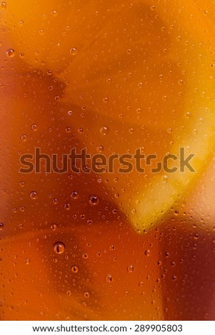 background texture of cold cola with dew drops, ice cubes and lemon