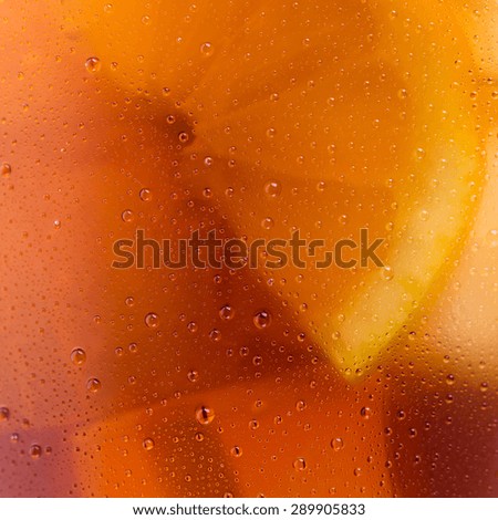 closeup from a cold coke glass with dew drops and lemon