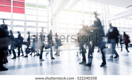Business People Walking at Rush Hour on a traid fair flloor