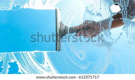cleaning window with squeegee blue sky