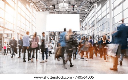 anonymous blurred people rushing at a trade fair