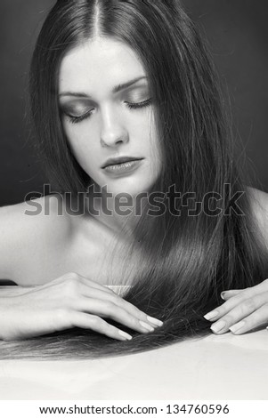 Portrait of beautiful young woman with long straight brown hair. Black and white