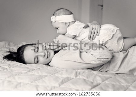 Closeup faces of young happy mother with cute newborn baby. Black and White