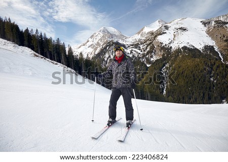 Smiling young man on skis in snow