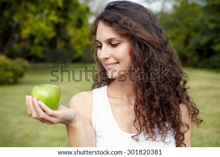 smiling woman holding apple.Outdoor