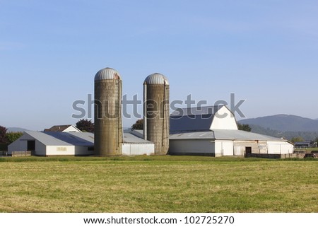 Two silos and farm buildings in a rural setting/Two Silos/Two silos used for farming