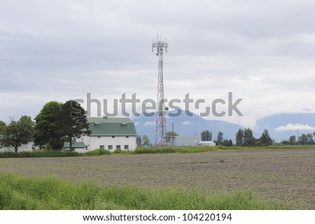 A transmission tower in a rural area used for receiving and sending signals for cellphone, telephone and other communicative devices/Signal Transmission Tower/Signal Transmission tower in rural area