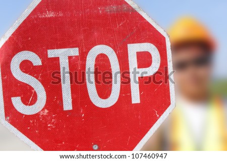 A flag person holds up a stop sign for on-coming motorists. /Flag Person Holds Stop Sign/A person is assigned to control traffic in a construction area.