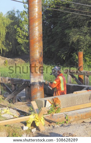 Grinding pylon used for bridge deck/A welder grinds a welding seal/Welder grinds seal on pylon