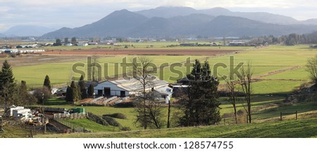 A wide angle view of a dairy farm in a valley/Valley Dairy Farm/A wide angle view of a dairy farm with calf hutches