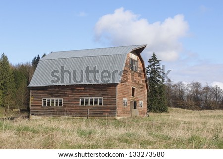 An old, wood frame - traditional barn is fitted with a new metal roof/Old Barn, New Roof/An old, wood frame - traditional barn is fitted with a new metal roof.