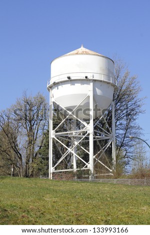 An industrial sized water tank near a factory/Industrial Water Tank/An industrial sized water tank near a factory.