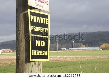 A rural sign on a farm warns that this is private property and no trespassing/Private Property No Trespassing/A rural sign on a farm warns that this is private property and no trespassing
