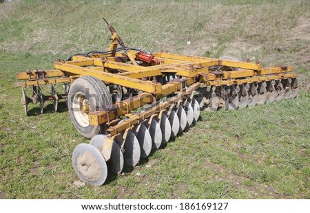 A plow with angled discs is used to prepare a field for planting crops. /Disc Plow/A plow with angled discs is used to prepare a field for planting crops.