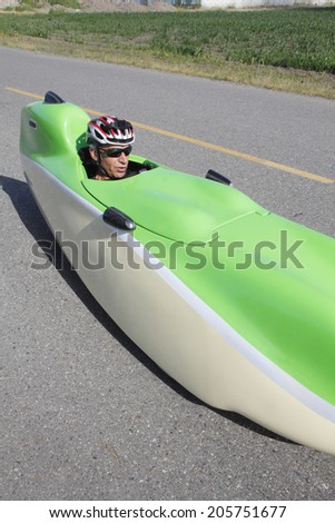 SUMAS, BC/CANADA - JULY 16: A man pedals past in his aerodynamic and light weight velomobile or bicycle car in BC\'s southeastern Fraser Valley on July 16, 2014.