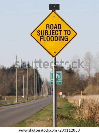 A sign warns that the road is subject to flooding/Flooding Sign/A sign warns that the road is subject to flooding