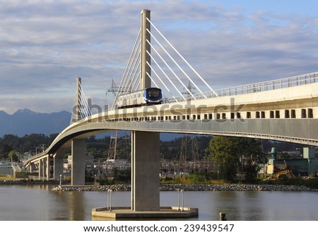 VANCOUVER, BC/CANADA JUNE 10 2014: Rapid transit or the Canada Line on the south end of Vancouver, British Columbia as a skytrain crosses the Fraser River.