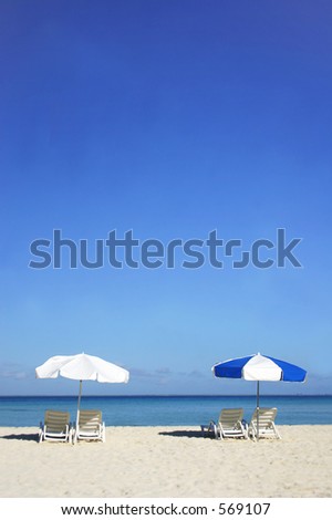 Two sun umbrellas on tropical beach