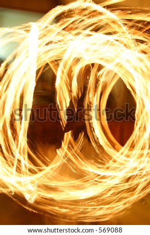 Swirling fire effect from long exposure of man with juggling torches