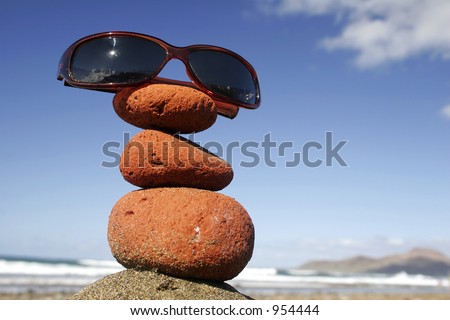 Sunglasses on stone stack by the beach