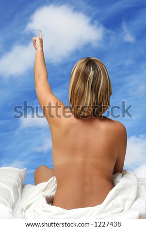 Woman in bed pointing out of the window to the sky