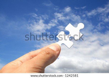Hand holding jigsaw piece as key