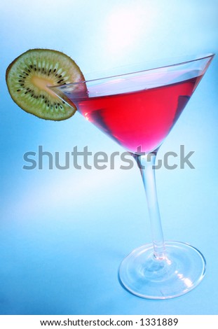 Red cocktail with kiwi garnish with blue background