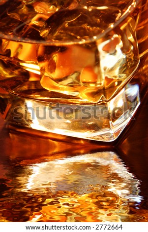 Backlit whiskey in glass tumbler with reflection