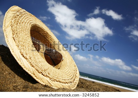 Summer hat and sunglasses on a sunny beach