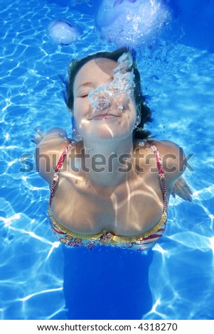 Wet female swimsuit bra or brassiere floating in water of swimming pool  Stock Photo