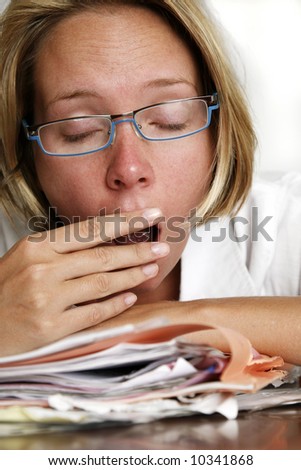 Woman looking very tired with pile of documents